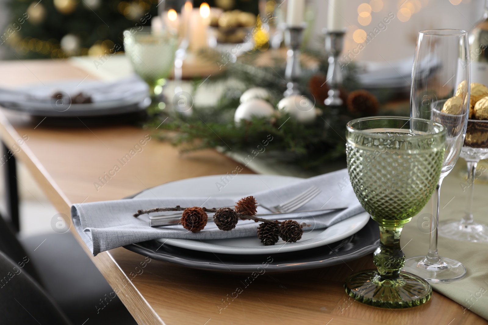 Photo of Christmas table setting with festive decor and dishware indoors