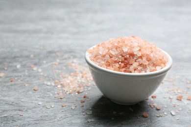 Photo of Pink himalayan salt on grey table, closeup. Space for text