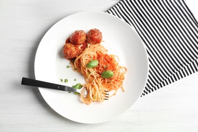 Photo of Delicious pasta with meatballs and tomato sauce on wooden background