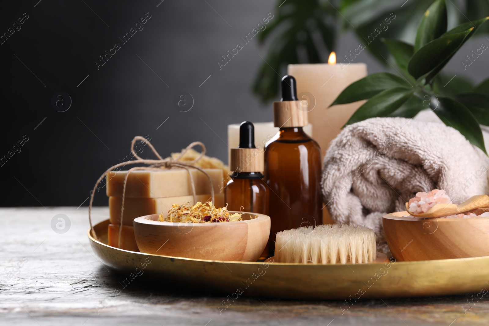 Photo of Spa composition. Dry flowers, bottles and soap bars on table, closeup