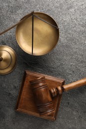 Photo of Law concept. Judge's mallet and scales of justice on dark grey table, top view