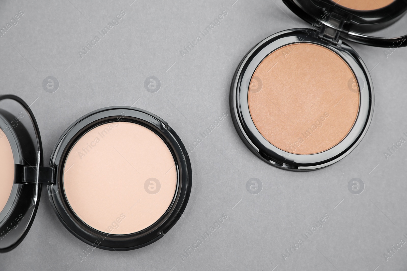 Photo of Open face powders on light grey background, flat lay