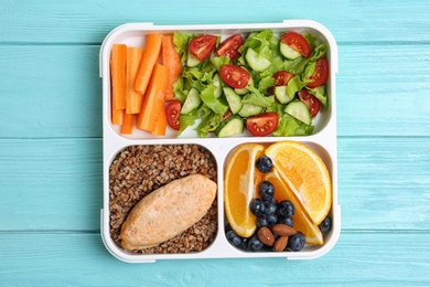 Tray with healthy food for school child on light blue table, top view