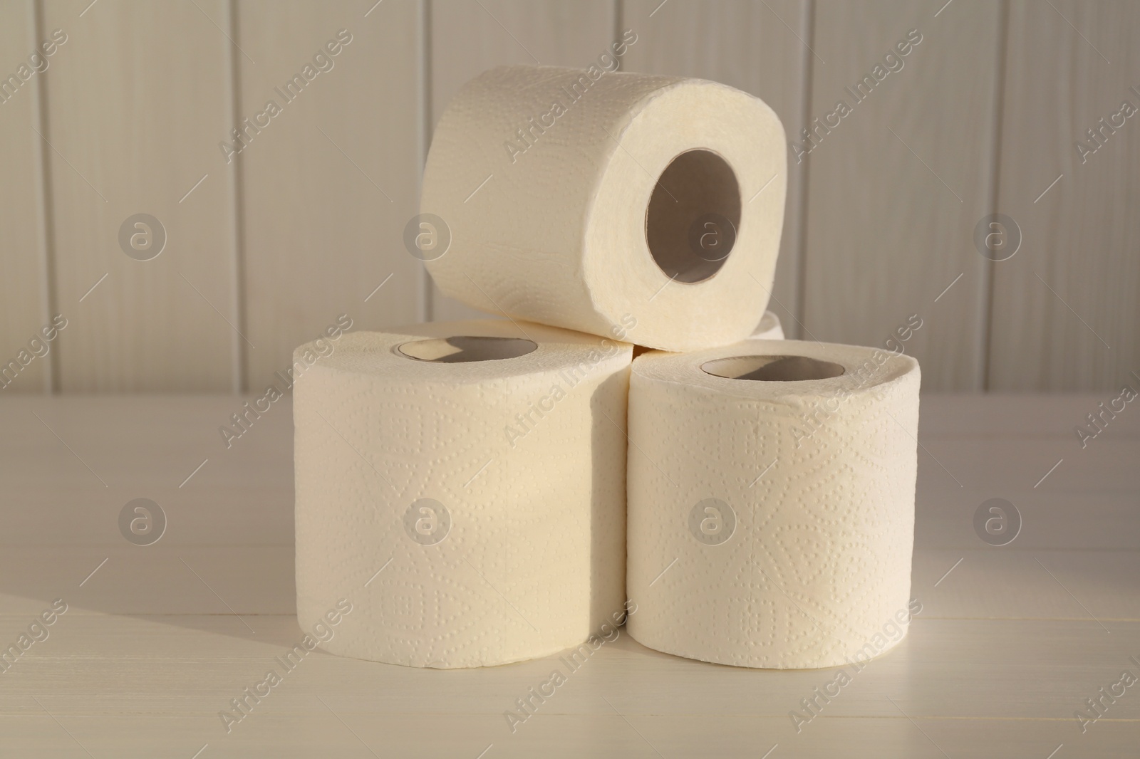 Photo of Many soft toilet paper rolls on white wooden table