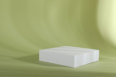 Photo of Presentation of product. Podium and shadows on light green background. Space for text