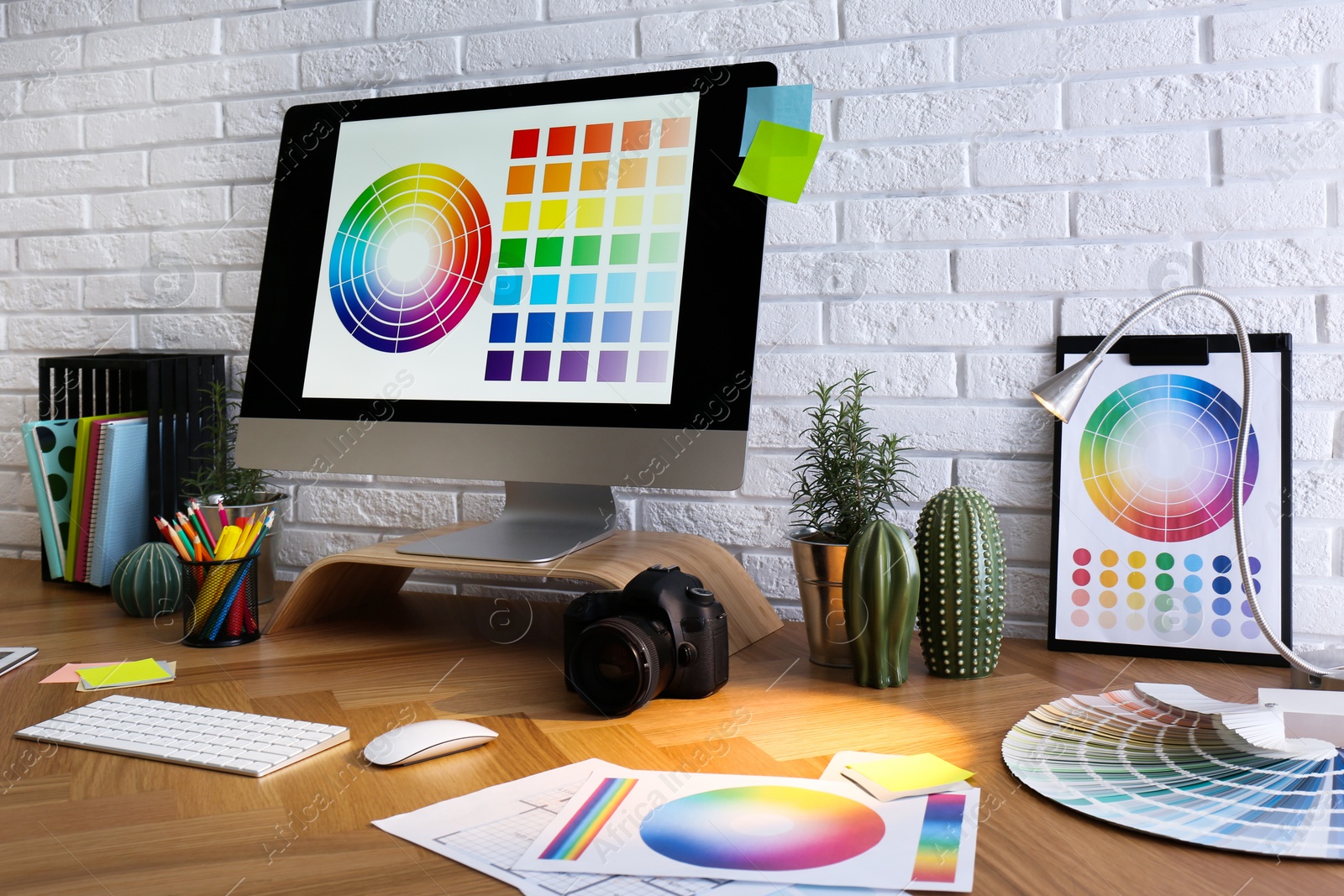 Photo of Modern computer and office supplies on wooden table. Designer's workplace