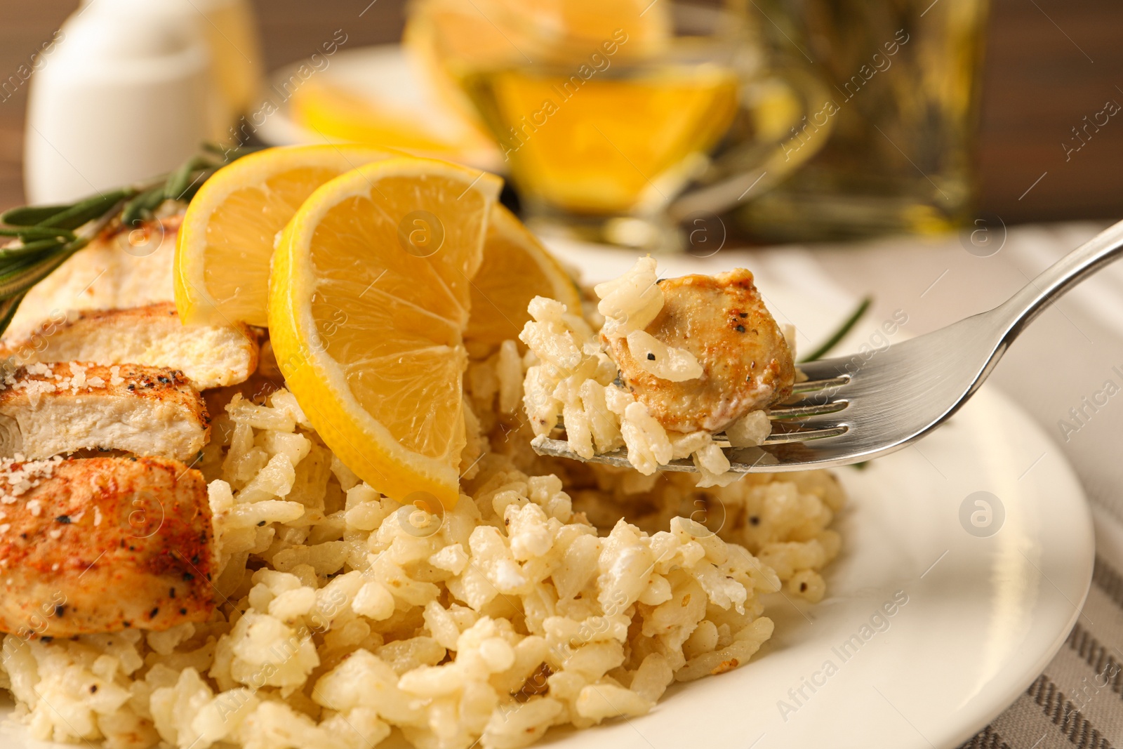 Photo of Delicious chicken risotto with lemon on table, closeup