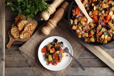 Photo of Delicious ratatouille served on wooden table, flat lay