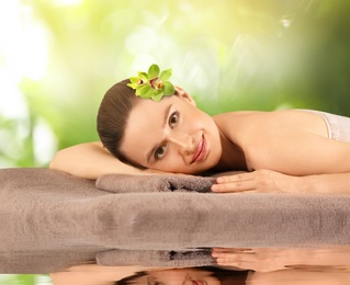 Beautiful young woman relaxing on soft towel. Spa treatment