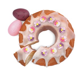 Photo of Festively decorated Easter cake and painted eggs on white background, top view