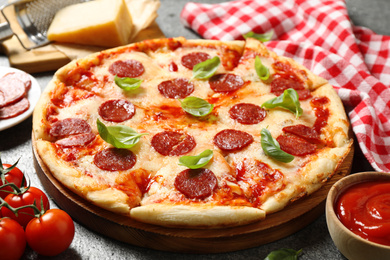 Photo of Hot delicious pepperoni pizza on grey table