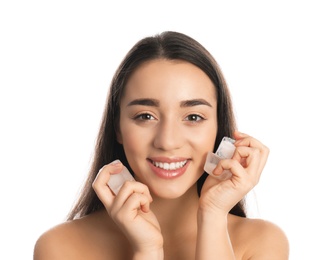Photo of Young woman with ice cubes on white background. Skin care