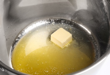 Piece of melting butter in pot, closeup