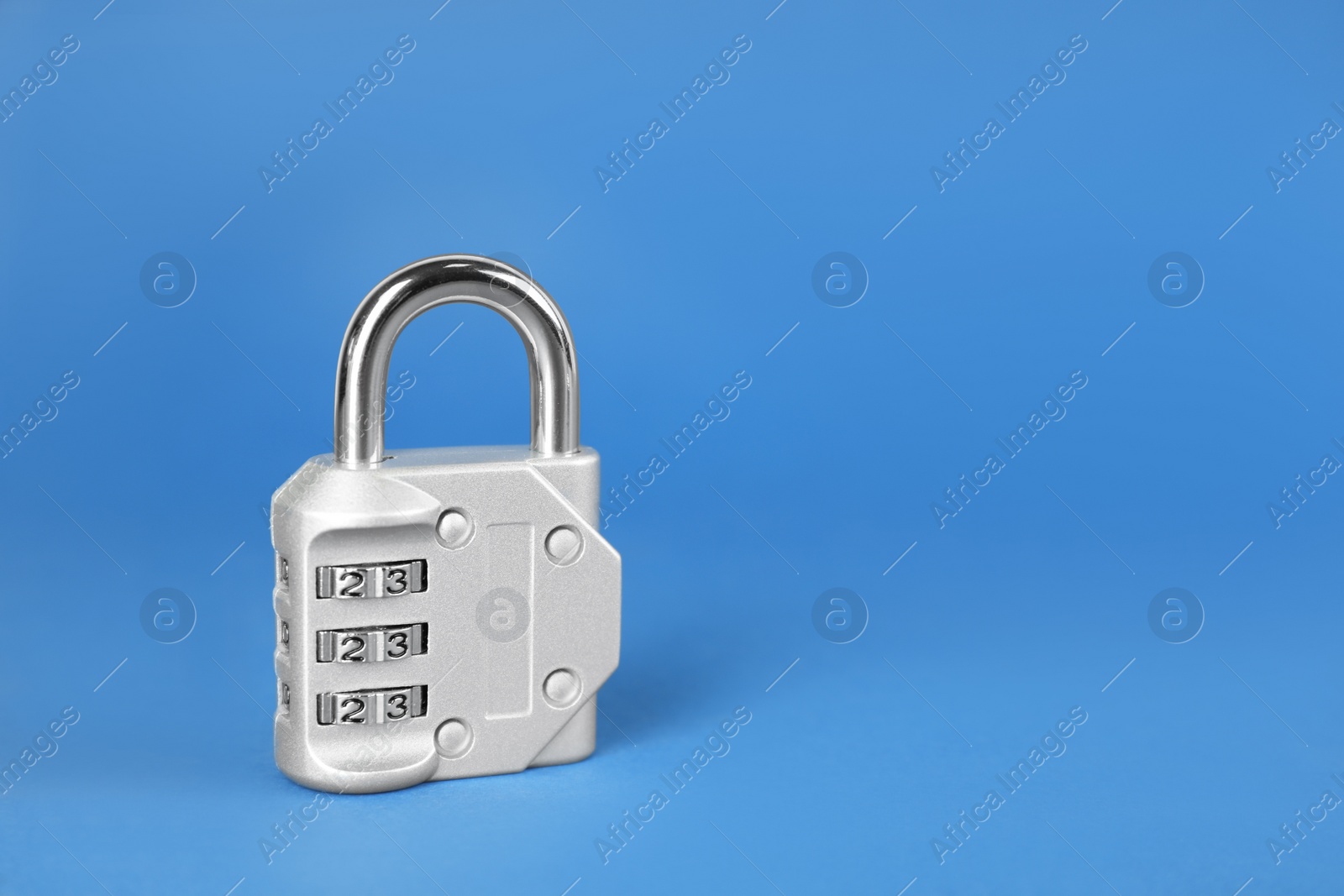 Photo of Modern combination lock on blue background. Space for text