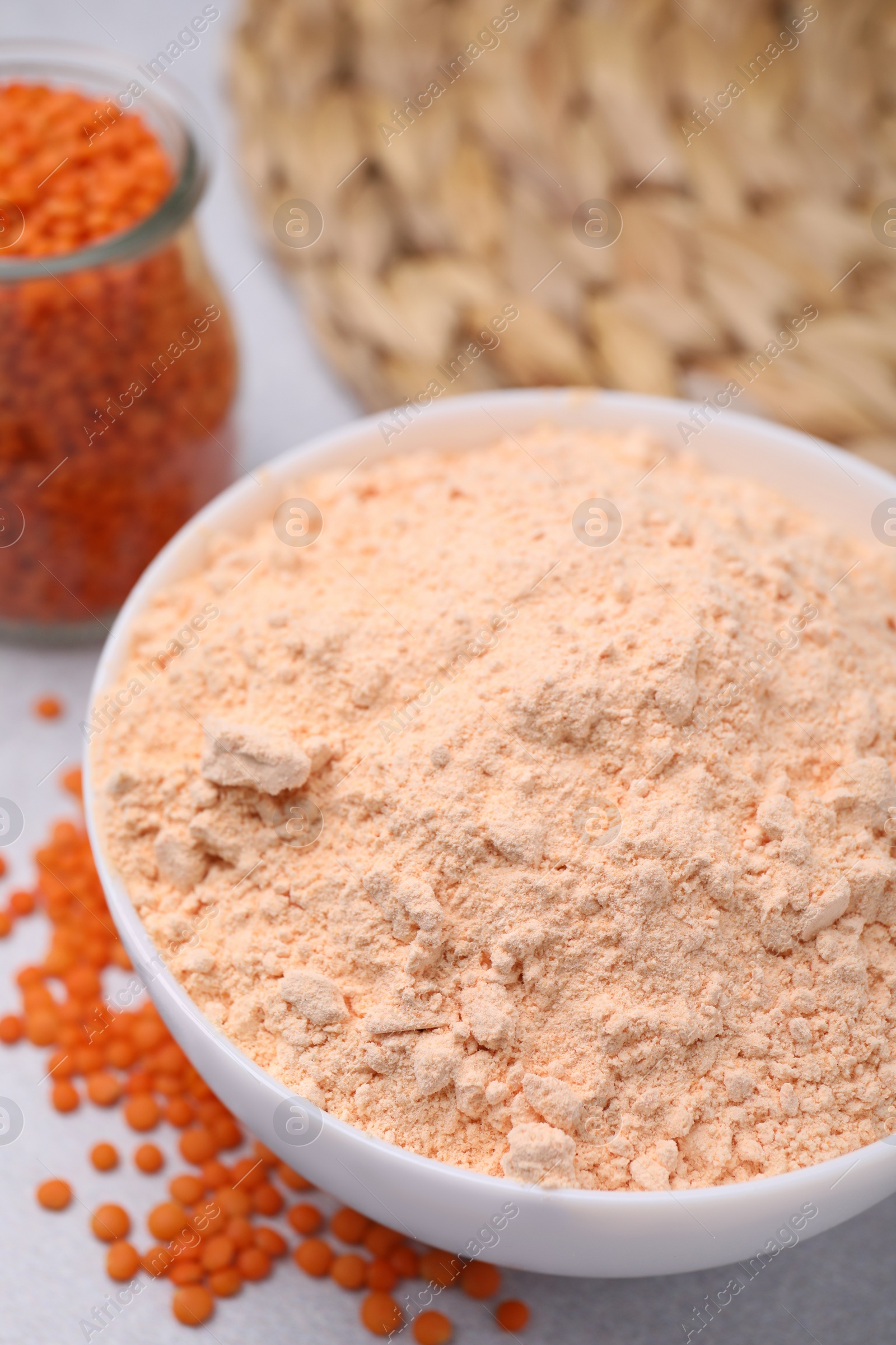 Photo of Lentil flour and seeds on white table, closeup