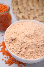 Photo of Lentil flour and seeds on white table, closeup