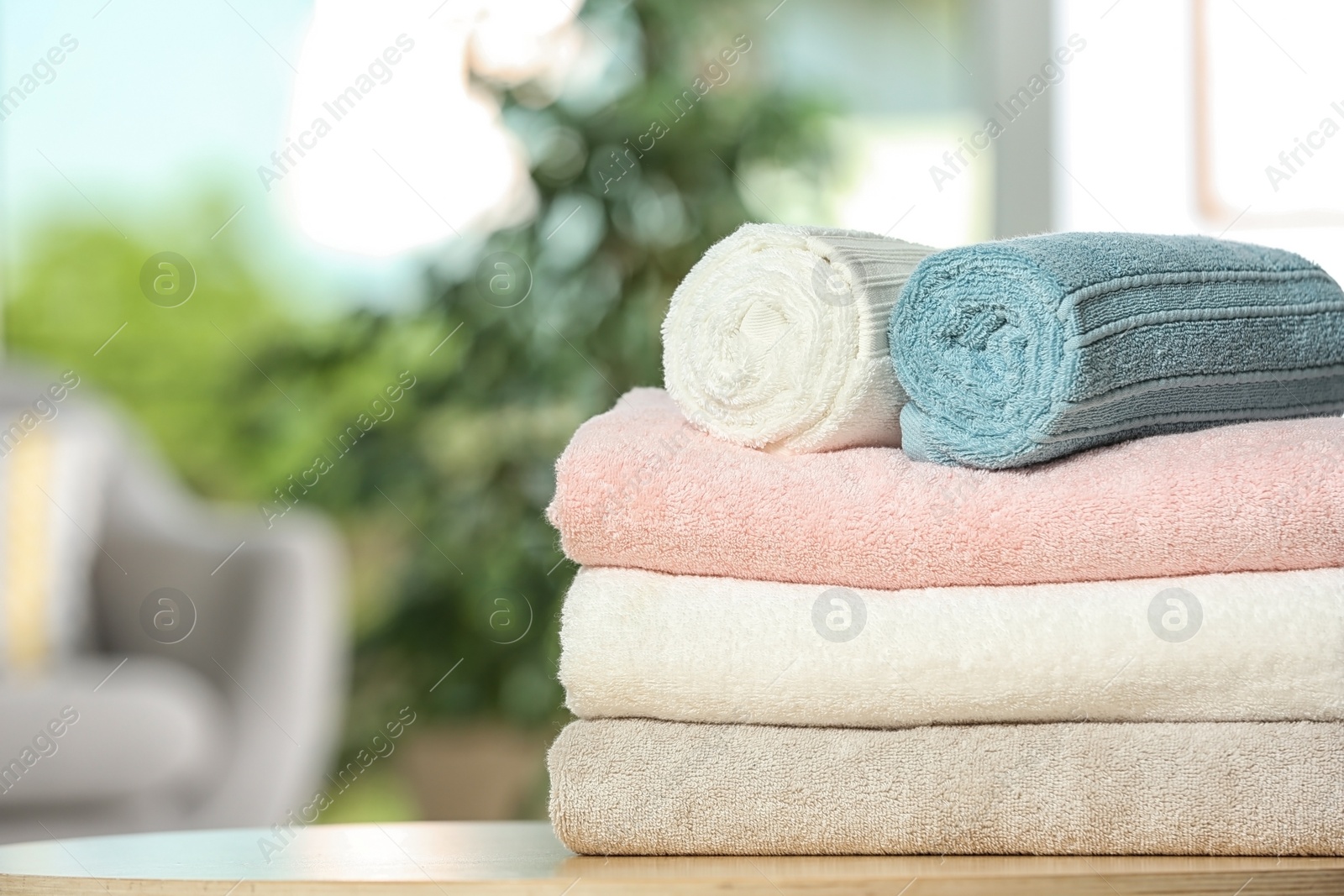 Photo of Clean soft terry towels on table indoors, closeup. Space for text