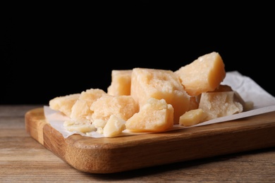 Photo of Pieces of delicious parmesan cheese on wooden table, closeup
