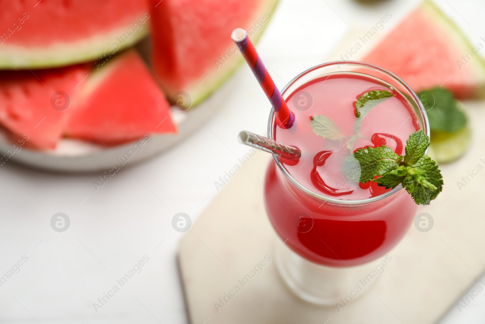 Photo of Delicious fresh watermelon drink on white wooden table, closeup