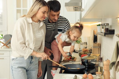 Photo of Happy lovely family cooking together in kitchen