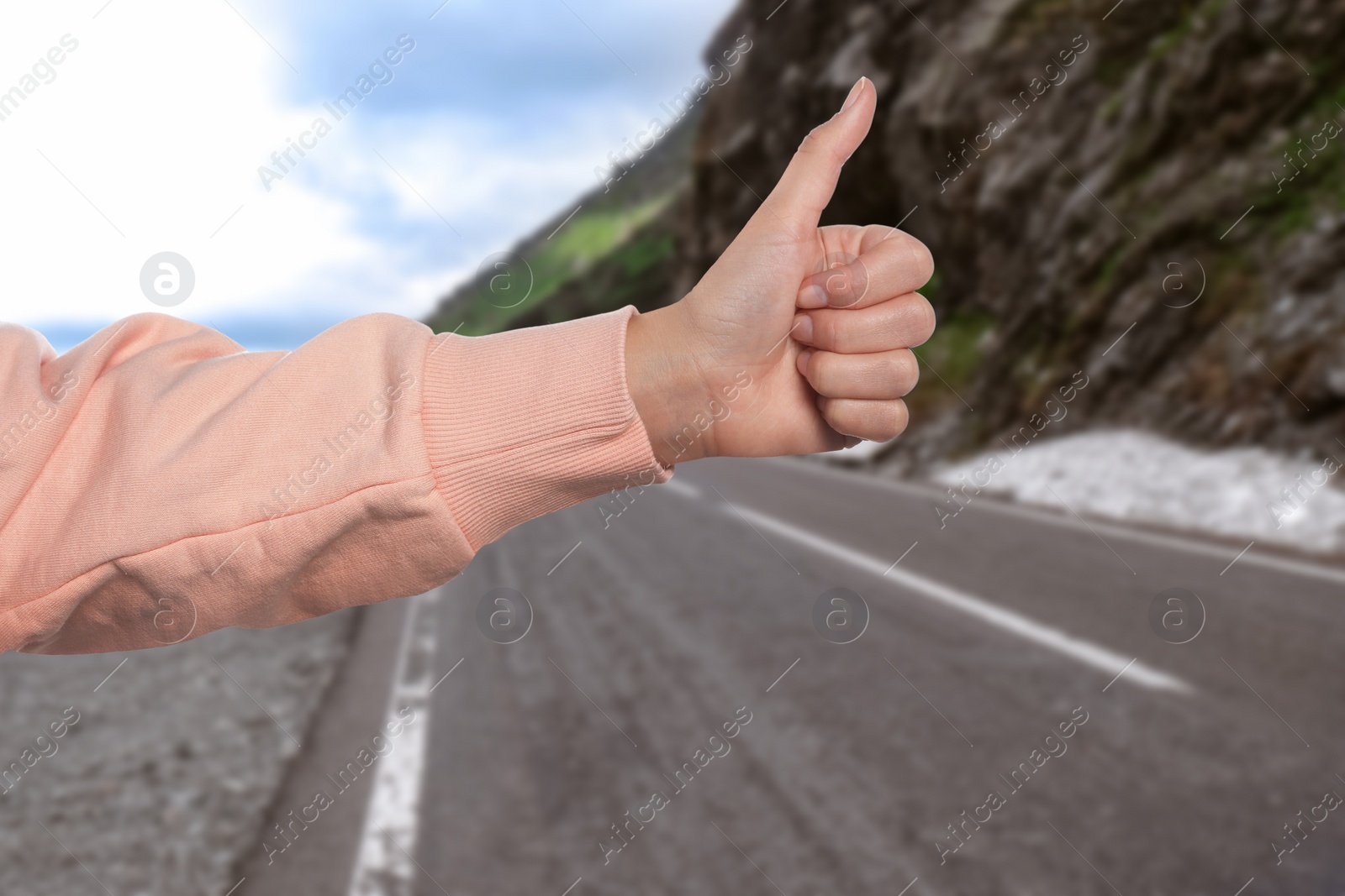 Image of Woman catching car on road, closeup. Hitchhiking trip