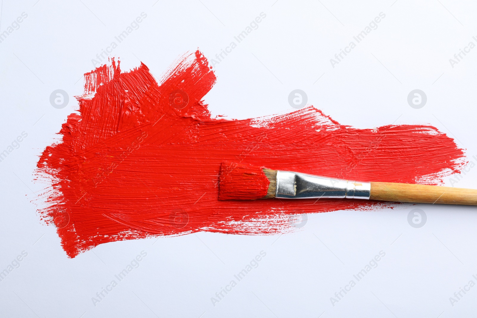 Photo of Paint stroke and brush on white background, top view