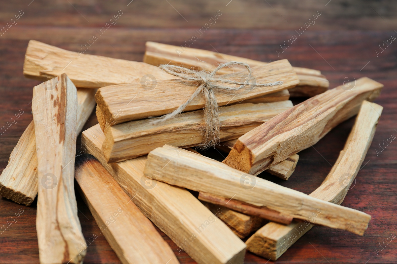 Photo of Many palo santo sticks on wooden table, closeup