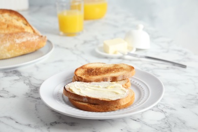 Tasty bread with butter served for breakfast on marble table