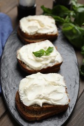 Bread with cream cheese on wooden table