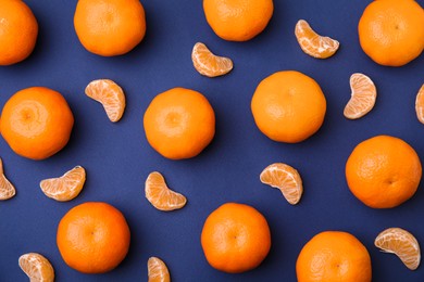Photo of Fresh juicy tangerines on blue table, flat lay