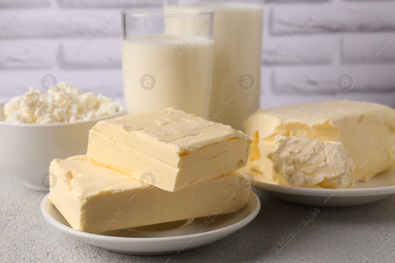 Photo of Tasty homemade butter and dairy products on white textured table