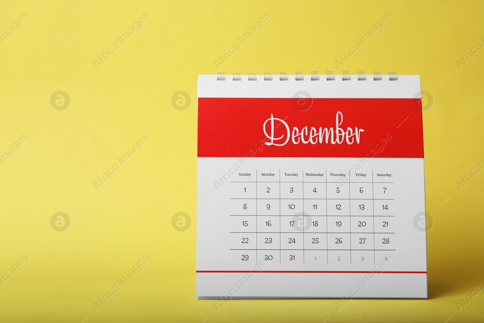 Photo of Paper calendar on yellow background, space for text. Planning concept