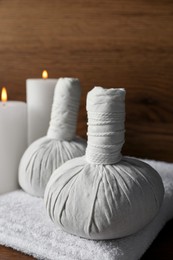 Beautiful spa composition with different care products and burning candles on wooden table, closeup