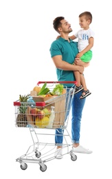 Father and son with full shopping cart on white background