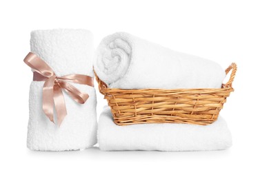 Photo of Wicker basket and rolled bath towels isolated on white