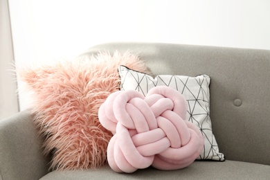 Photo of Different soft pillows on sofa in room. Interior element