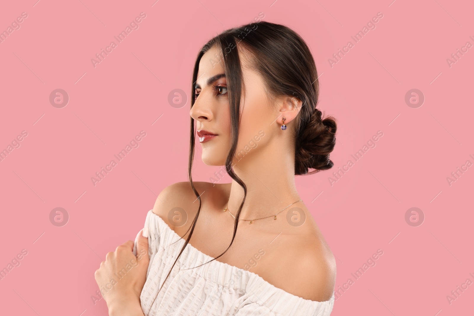 Photo of Beautiful woman with elegant jewelry on pink background