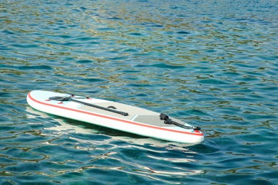 Photo of One SUP board with paddle on sea water