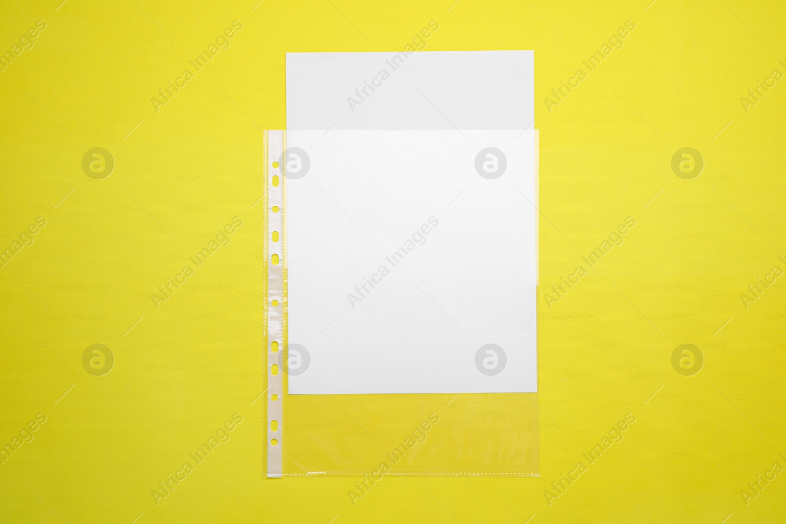 Photo of Punched pockets on yellow background, top view