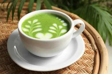 Photo of Delicious matcha latte in cup on coffee table, closeup