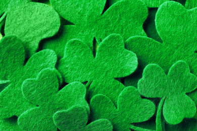 Green clover leaves as background, top view. St. Patrick's Day celebration