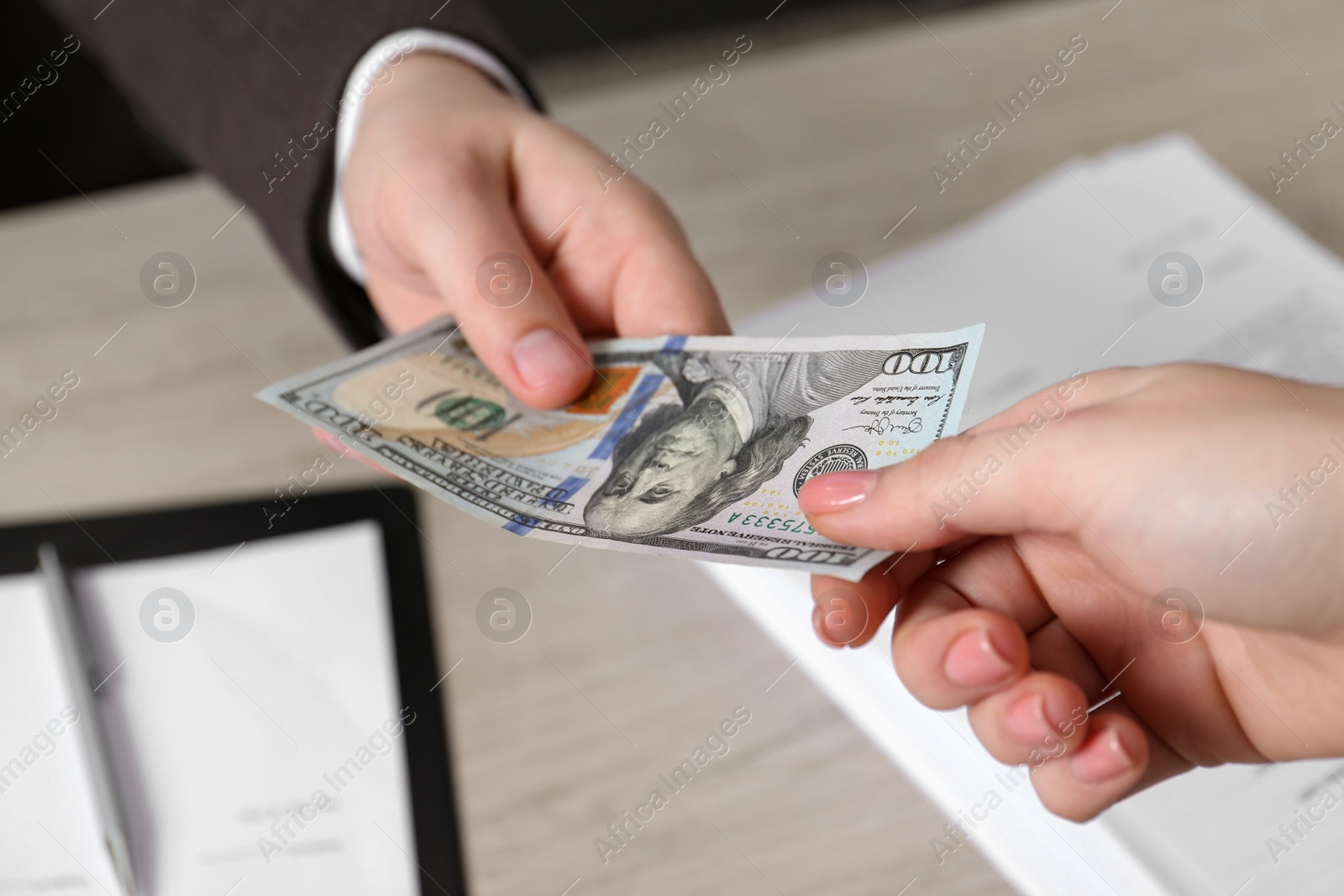 Photo of Man giving money to woman at light table, closeup. Currency exchange