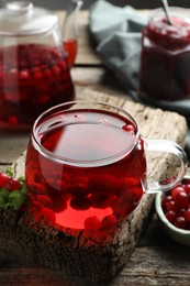 Photo of Delicious cranberry tea and berries on wooden table