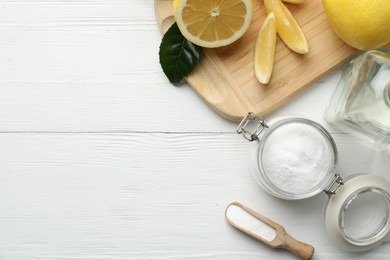 Photo of Baking soda, vinegar and cut lemons on white wooden table, flat lay. Space for text
