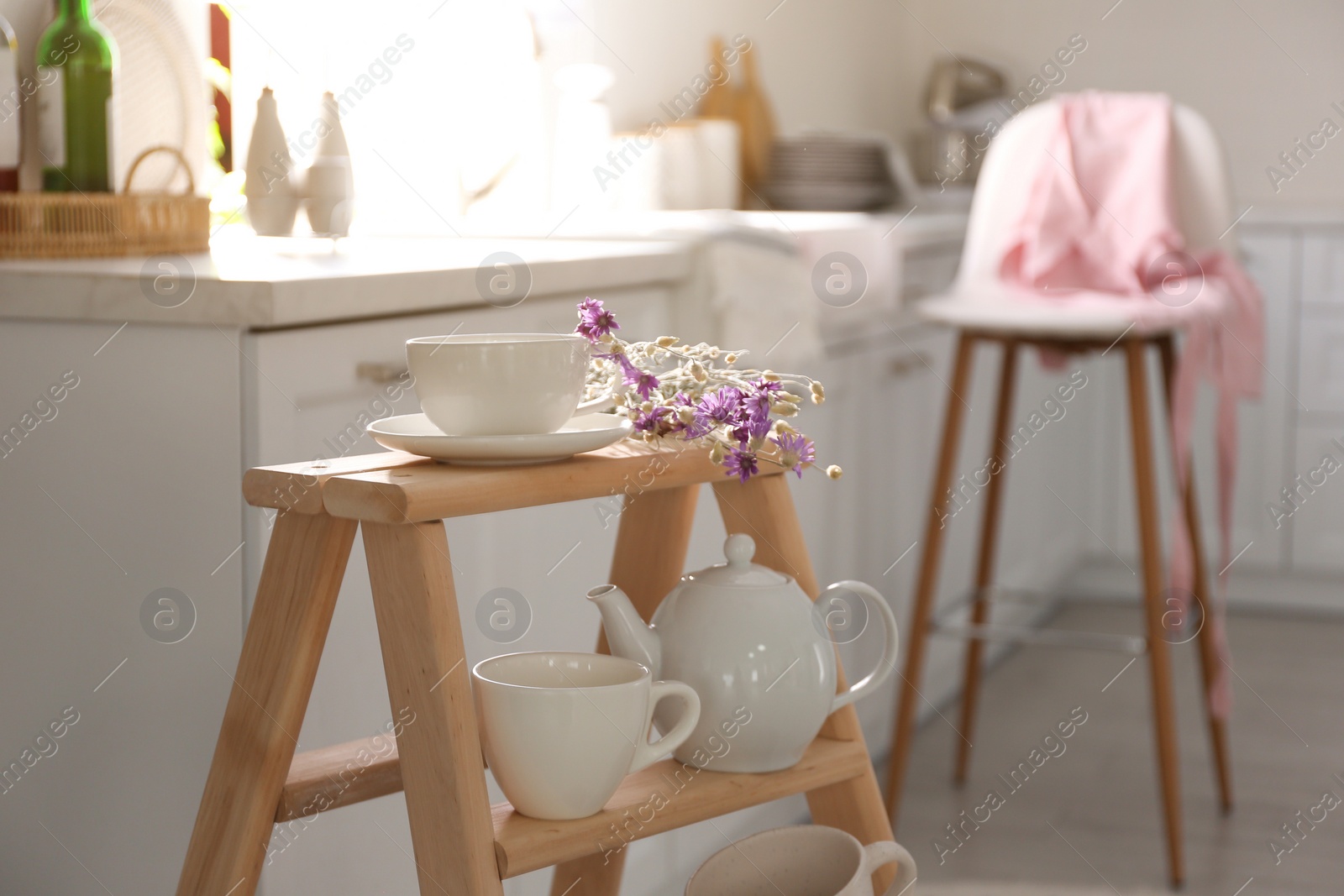 Photo of Decorative ladder with different dishware in kitchen. Idea for interior design
