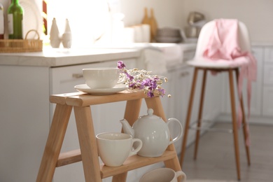 Decorative ladder with different dishware in kitchen. Idea for interior design