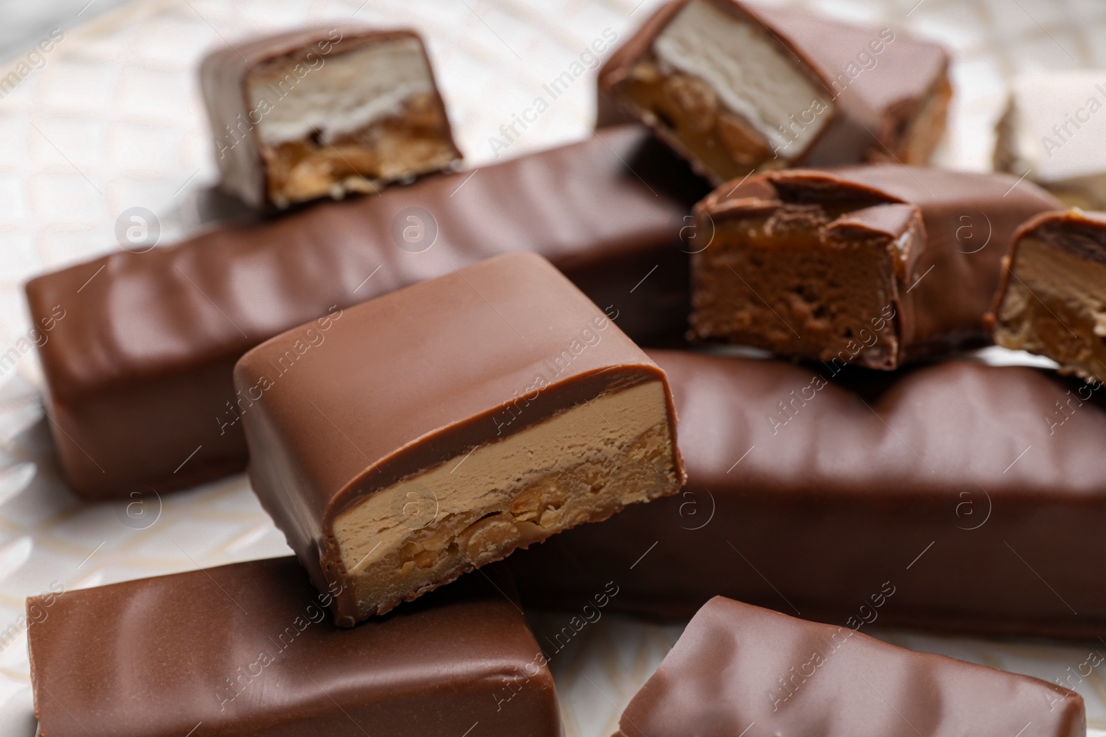 Photo of Tasty chocolate bars with nougat on light background, closeup