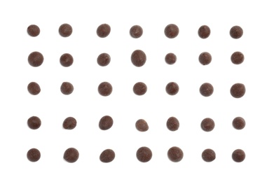 Delicious dark chocolate chips on white background, flat lay