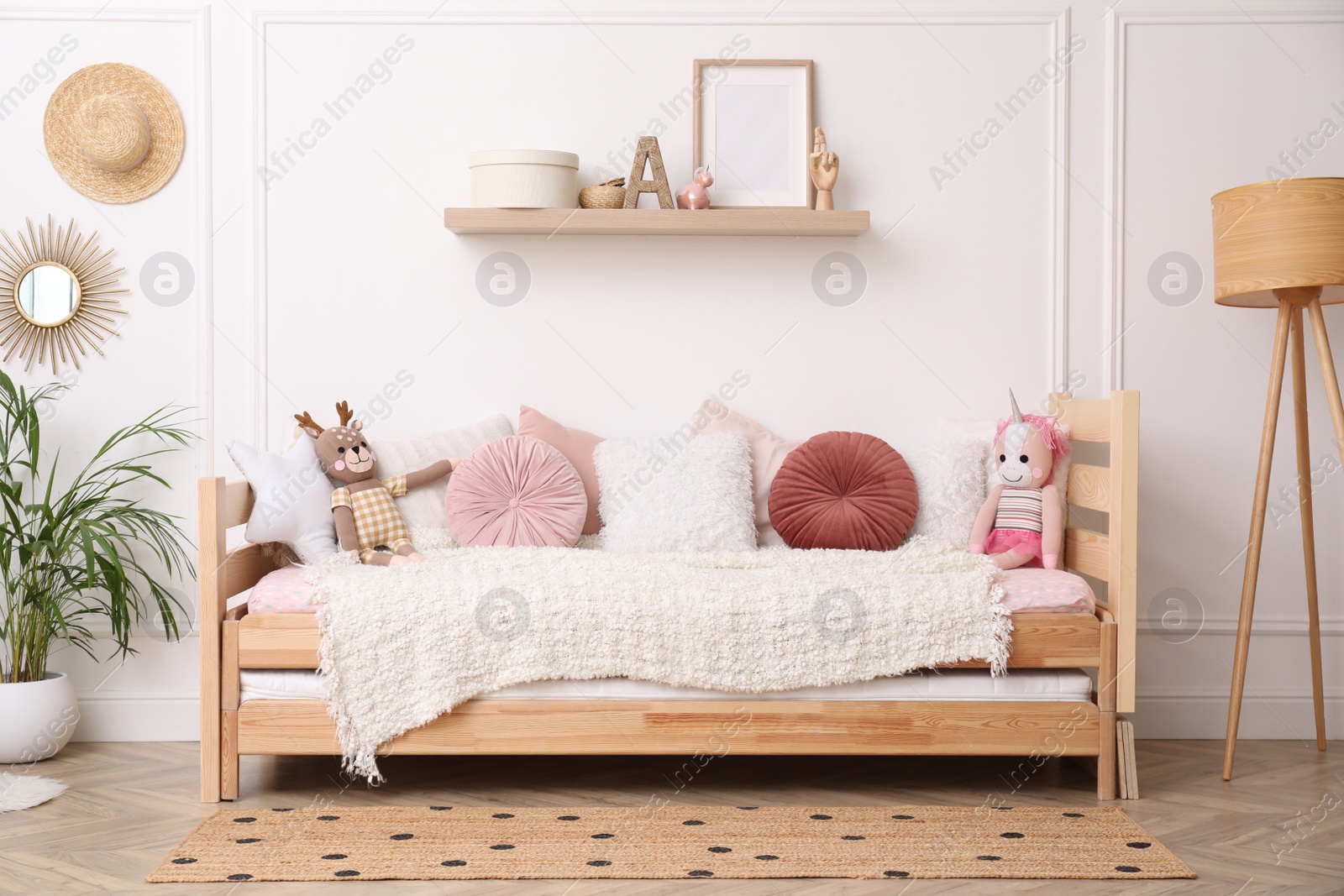 Photo of Cute child's room interior with comfortable bed and toys