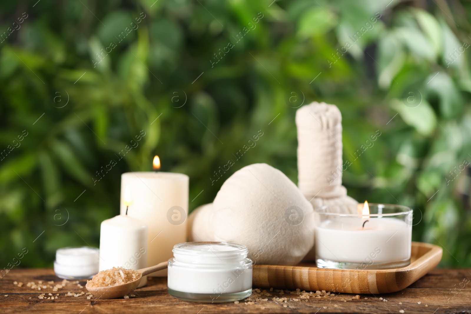 Photo of Beautiful spa composition with cream and candles on wooden table